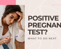 A young black woman looking at her positive pregnancy test, unsure of the next steps.