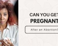 Concerned woman holding abortion pills, wondering about fertility after an abortion—Problem Pregnancy Center offers free ultrasounds and pregnancy tests.